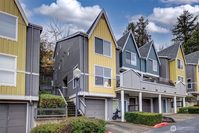 townhome / multi-family property with board and batten siding, an attached garage, and a residential view