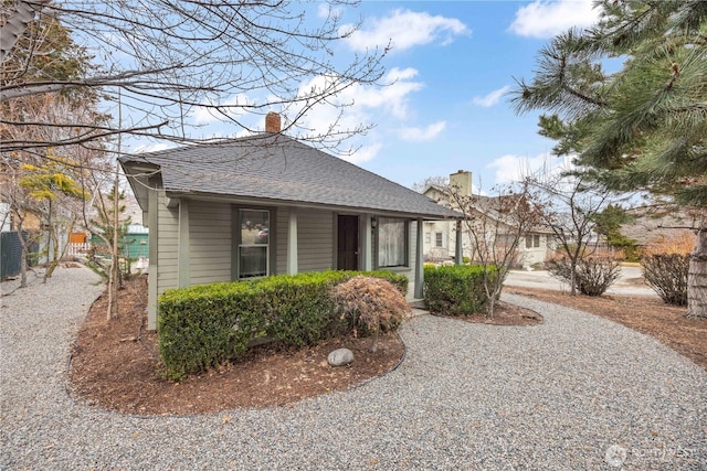 view of property exterior with a chimney and a shingled roof