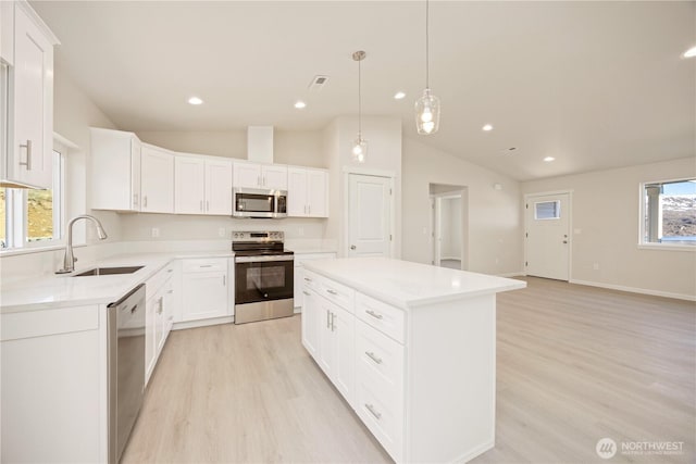 kitchen featuring a sink, a center island, light wood-style floors, and stainless steel appliances