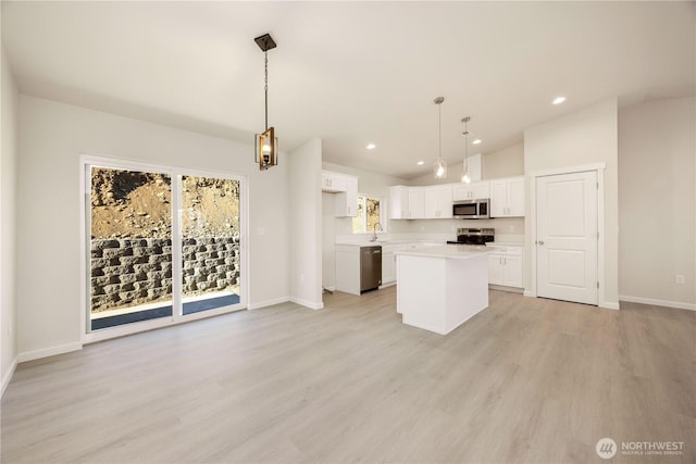 kitchen featuring white cabinetry, vaulted ceiling, appliances with stainless steel finishes, and a center island