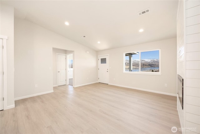 unfurnished living room featuring visible vents, a tile fireplace, light wood-style floors, and lofted ceiling
