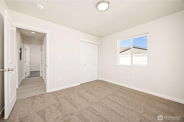 unfurnished bedroom with carpet, baseboards, and a closet