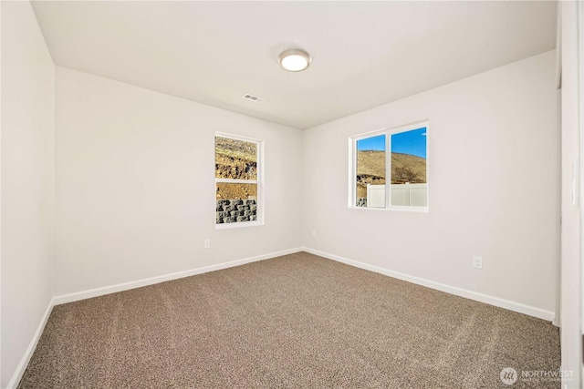carpeted spare room with baseboards and visible vents