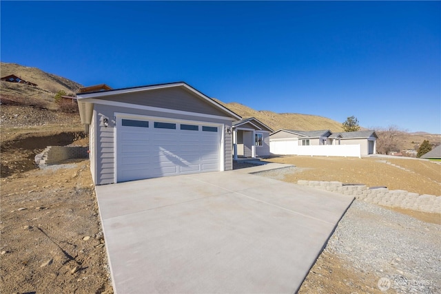 ranch-style house featuring an attached garage, a mountain view, and driveway