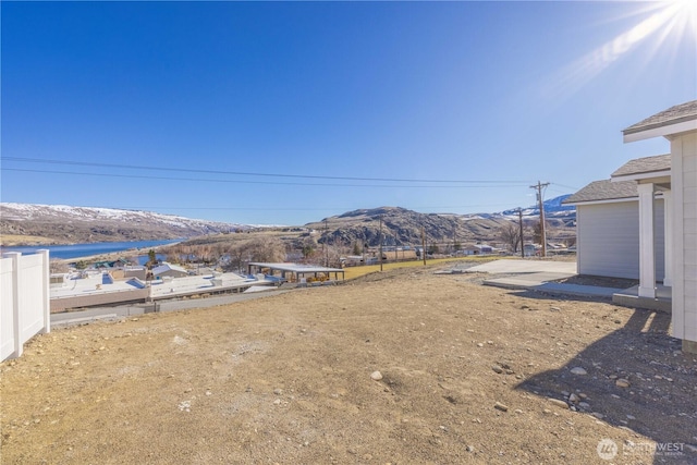 view of yard featuring fence and a mountain view