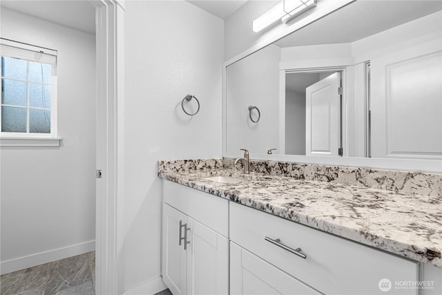 bathroom featuring vanity, baseboards, and marble finish floor