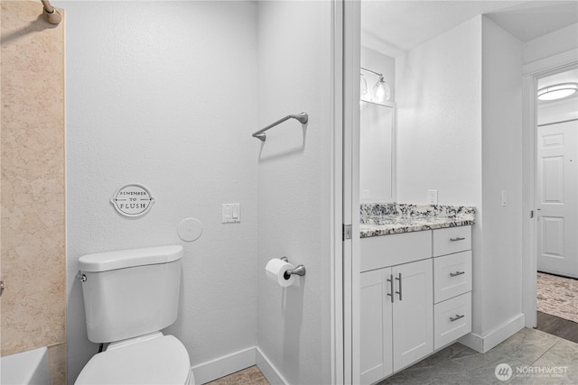 bathroom with toilet, vanity, and baseboards