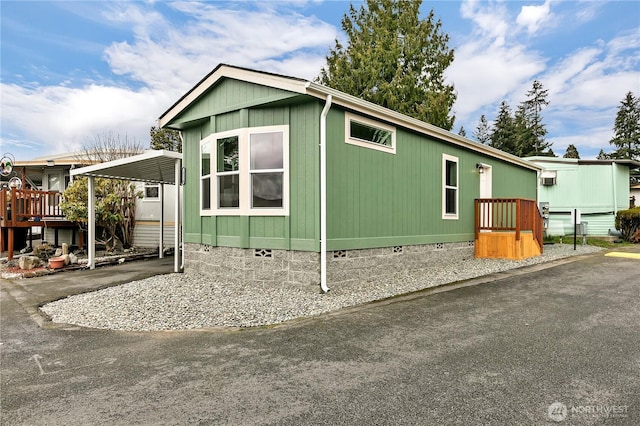 view of side of home with a carport, driveway, and crawl space