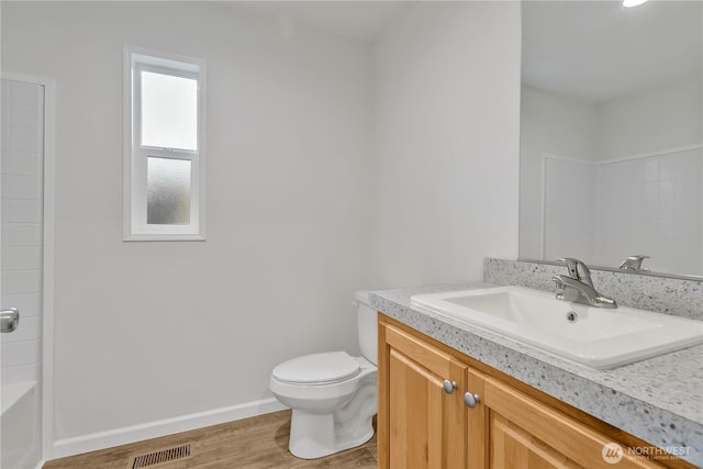 bathroom featuring visible vents, toilet, wood finished floors, baseboards, and vanity