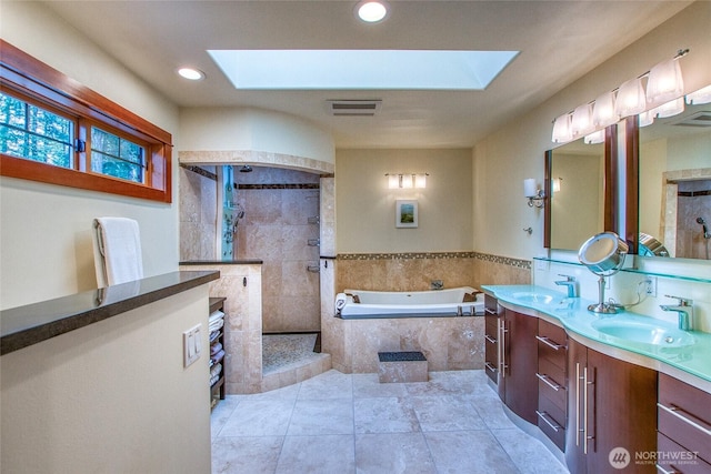 full bathroom featuring a skylight, a garden tub, tiled shower, double vanity, and recessed lighting