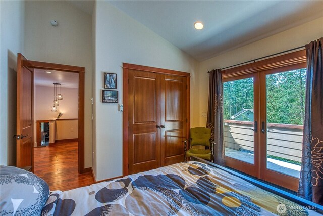 bedroom featuring wood finished floors, access to exterior, french doors, a closet, and high vaulted ceiling