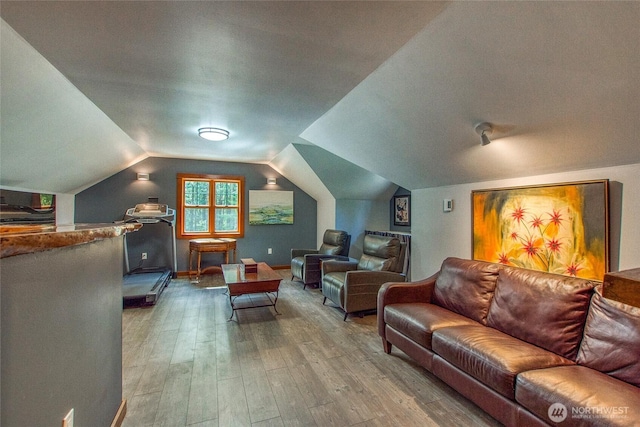 home theater with wood-type flooring and lofted ceiling