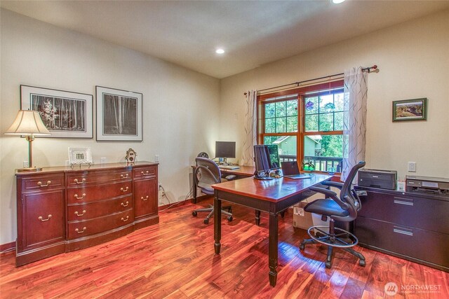 office with wood finished floors and recessed lighting