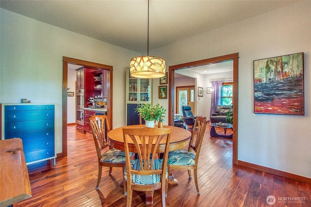 dining room featuring wood-type flooring and baseboards