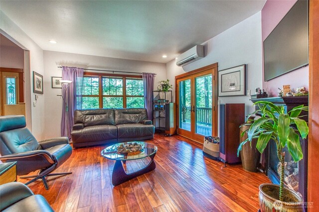 living room featuring a wall unit AC, plenty of natural light, hardwood / wood-style flooring, and recessed lighting