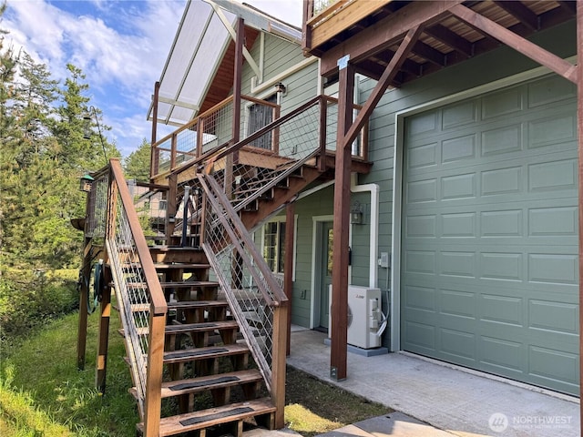 view of home's exterior featuring stairway, a garage, a wooden deck, and a cooling unit