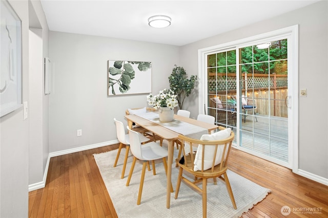 dining space with baseboards and wood-type flooring