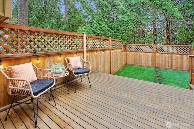 wooden terrace with a lawn and a fenced backyard