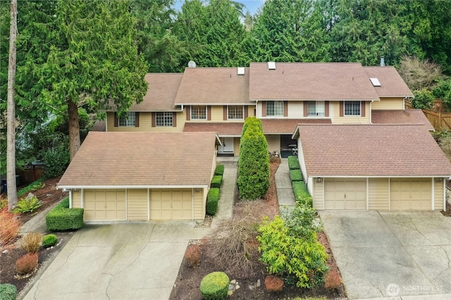 multi unit property with driveway and a shingled roof