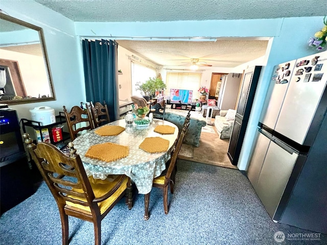 dining room featuring a ceiling fan, a textured ceiling, and carpet flooring