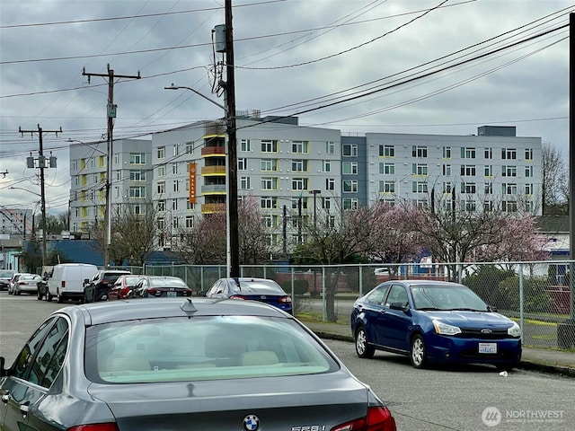 view of vehicle parking with fence