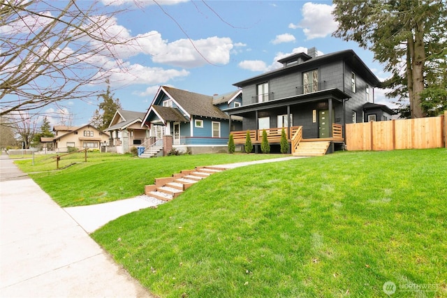 american foursquare style home with a front lawn and fence