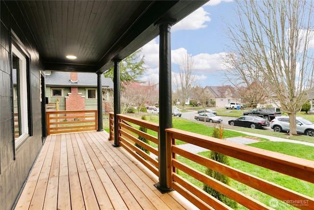 wooden terrace with a yard and covered porch