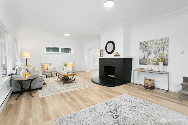 living room featuring baseboard heating, recessed lighting, a fireplace, and wood finished floors