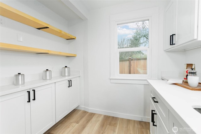 bar featuring light wood-type flooring and baseboards