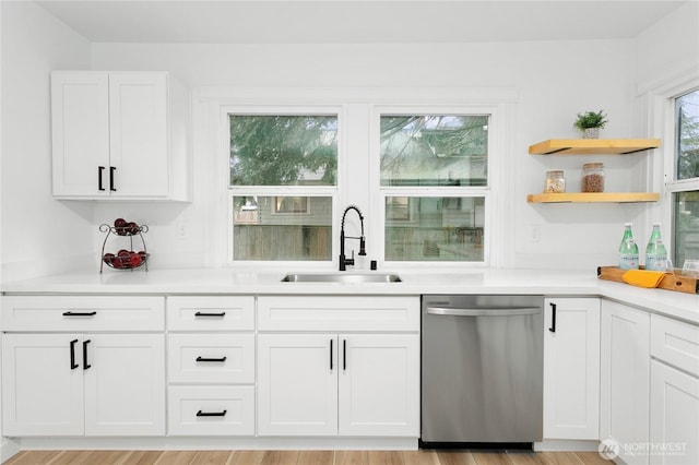 bar featuring light wood finished floors, a sink, and stainless steel dishwasher