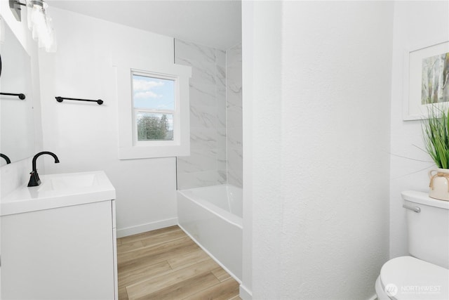 bathroom featuring toilet, vanity, baseboards, and wood finished floors