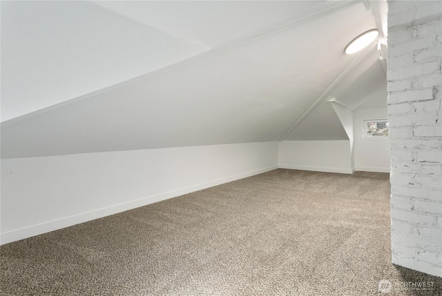 additional living space featuring vaulted ceiling, baseboards, and carpet floors