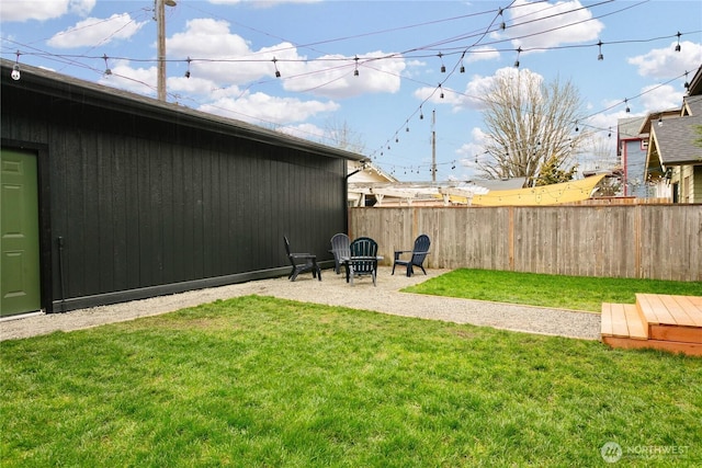 view of yard with a patio area, fence, and a fire pit