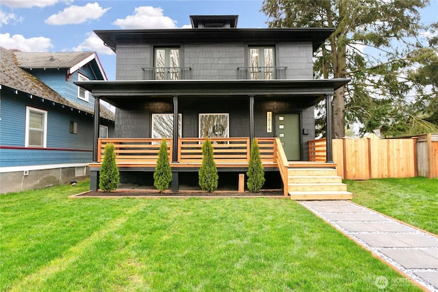 traditional style home with a porch, fence, french doors, a front yard, and a balcony