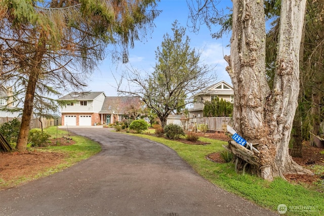 traditional home with fence, a garage, and driveway