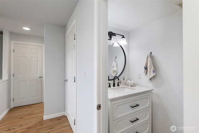bathroom with vanity, baseboards, recessed lighting, visible vents, and wood finished floors
