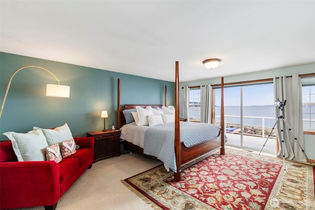 bedroom featuring a water view, carpet, and access to outside