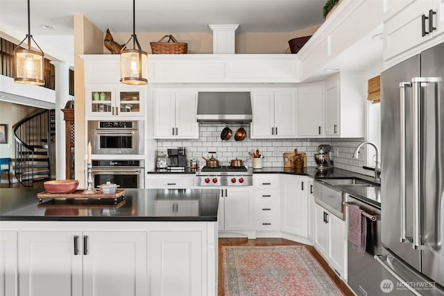 kitchen with dark countertops, stainless steel appliances, wall chimney exhaust hood, and tasteful backsplash