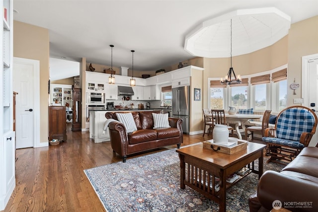 living area with an inviting chandelier, dark wood-style floors, and baseboards