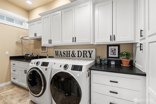 washroom featuring washing machine and dryer, cabinet space, baseboards, and a sink