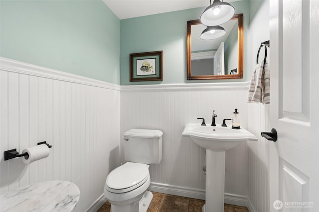 bathroom featuring wainscoting and toilet