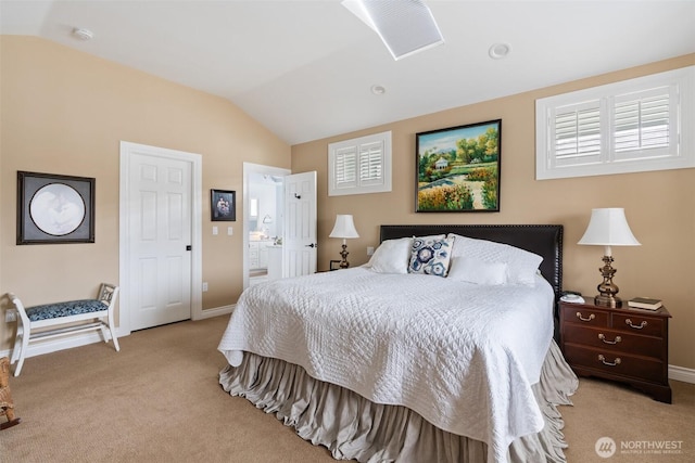 bedroom featuring ensuite bath, lofted ceiling, light colored carpet, and baseboards