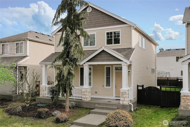 craftsman house with covered porch and fence