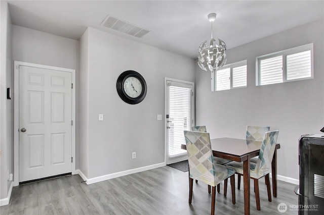 dining room with visible vents, baseboards, an inviting chandelier, and wood finished floors