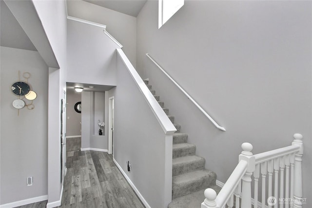 stairway with wood finished floors and baseboards