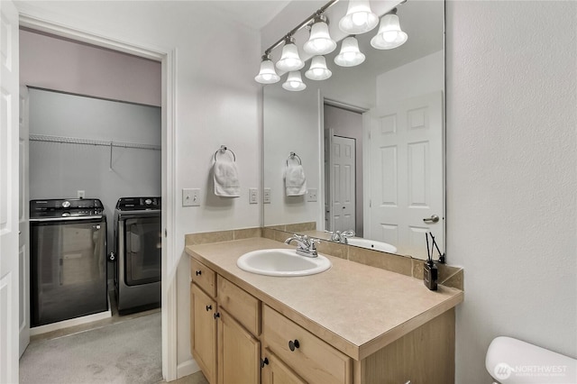 bathroom with separate washer and dryer, vanity, and toilet