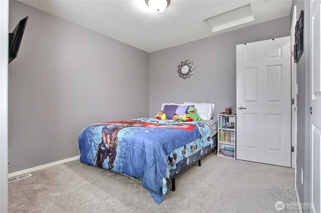 carpeted bedroom with visible vents, baseboards, and attic access