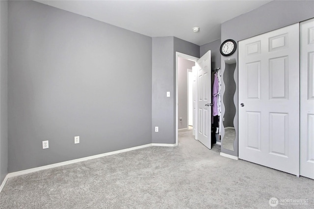 unfurnished bedroom featuring a closet, baseboards, and carpet floors