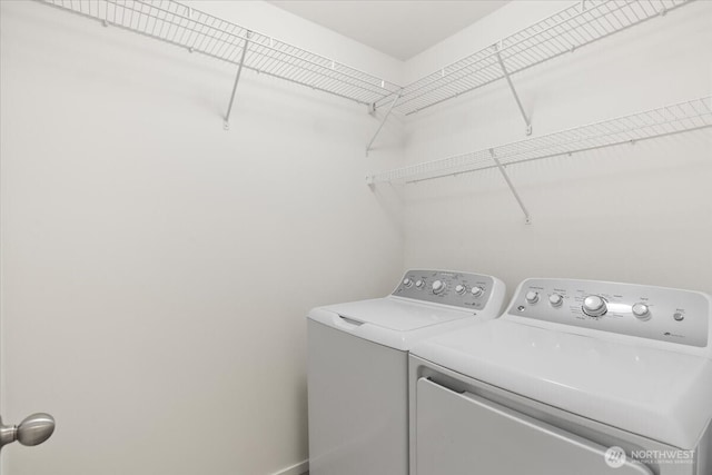 washroom with baseboards, washing machine and dryer, and laundry area