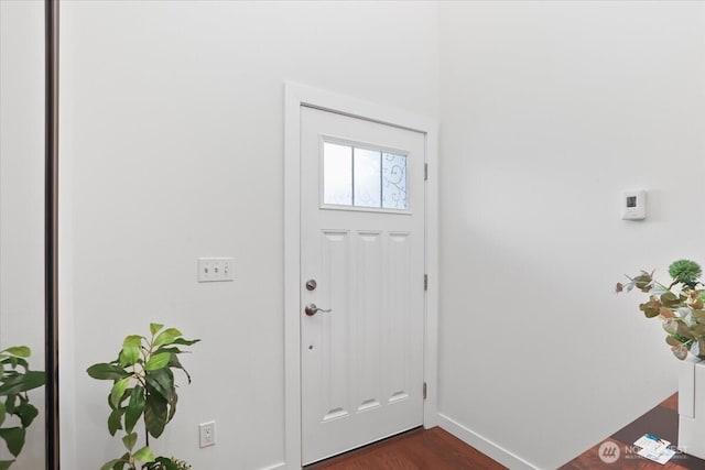 foyer entrance featuring dark wood-type flooring and baseboards